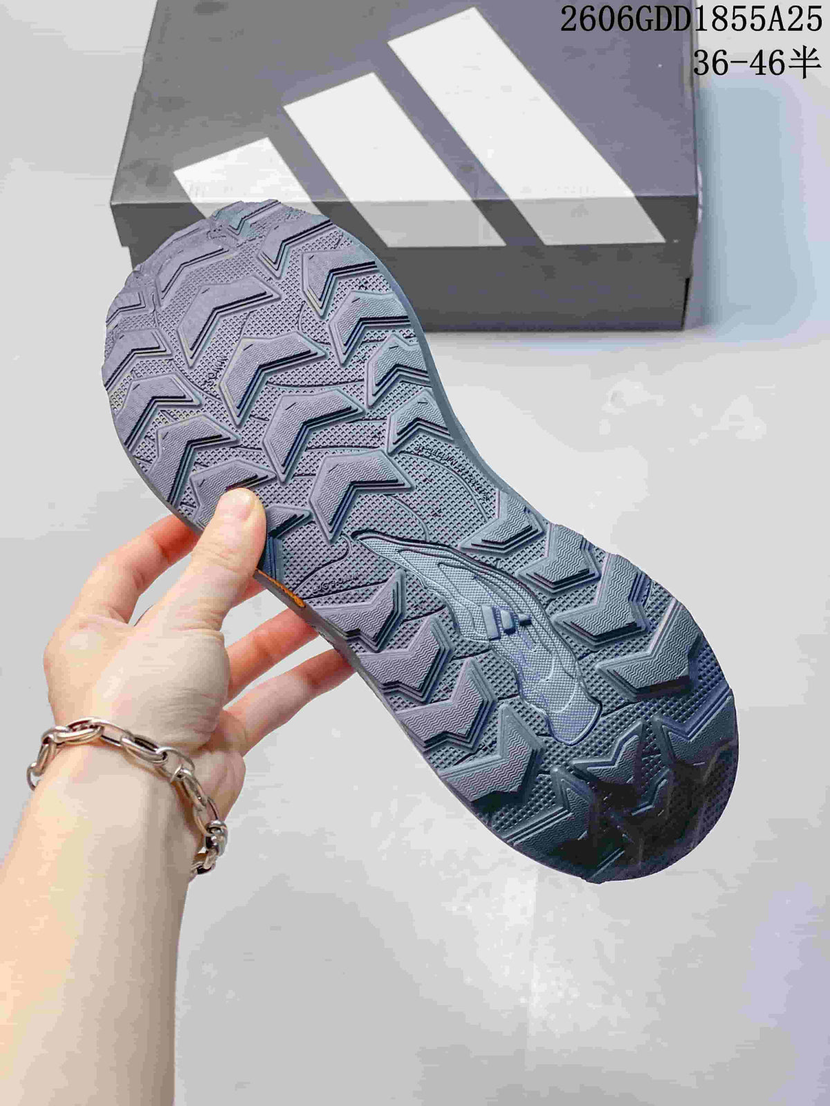 Close-up of the patterned outsole on a gray and blue trail running shoe