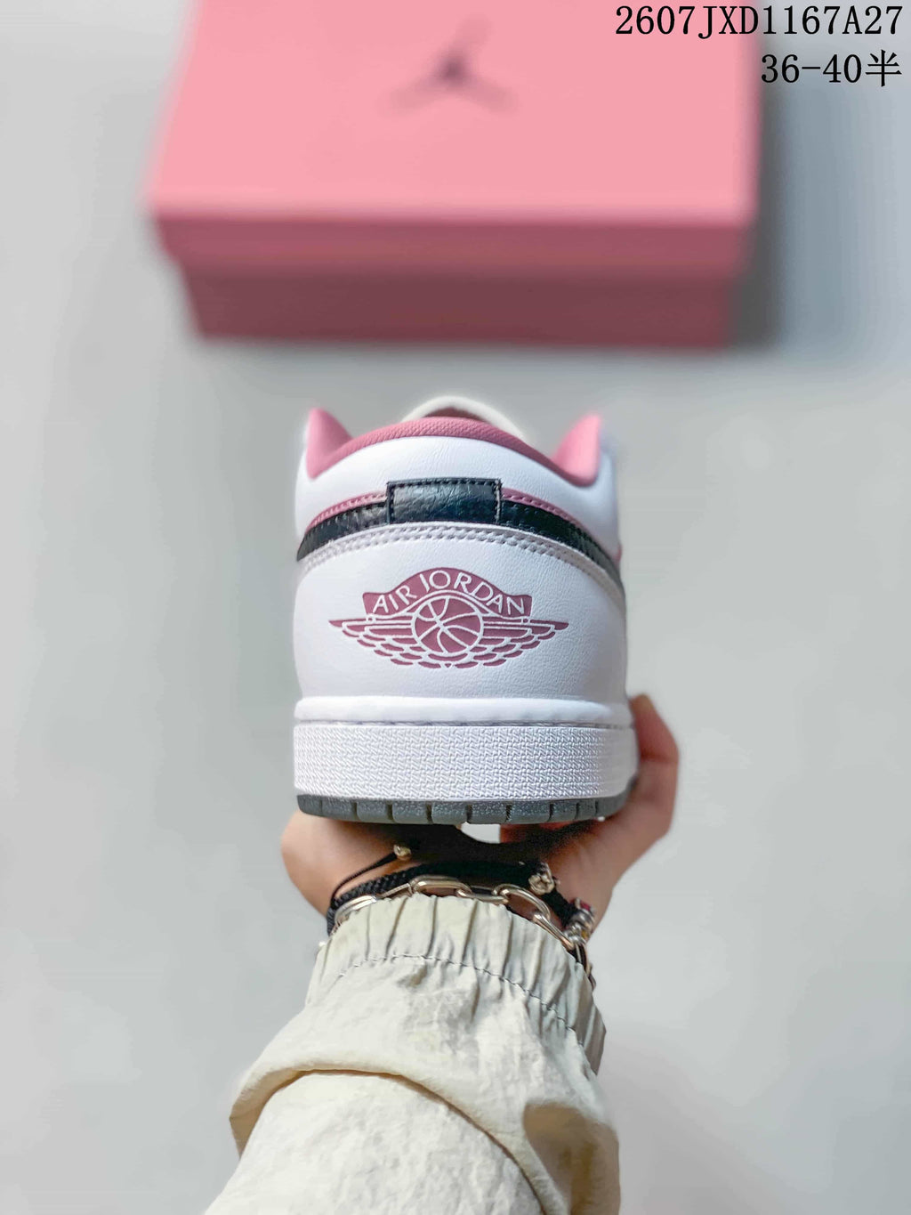 Rear view showing the Air Jordan Wings emblem, white heel, and pink collar details.