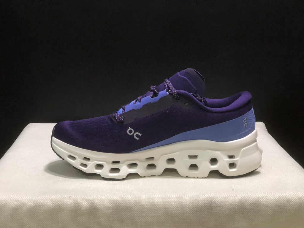 Outer side profile of a purple On Cloudmonster 3 shoe with blue heel detailing and a white sculpted midsole.