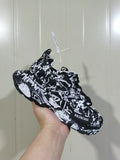 Balenciaga Track 3.0 sneaker shown from an angled side view in a black-and-white graffiti-style pattern.
