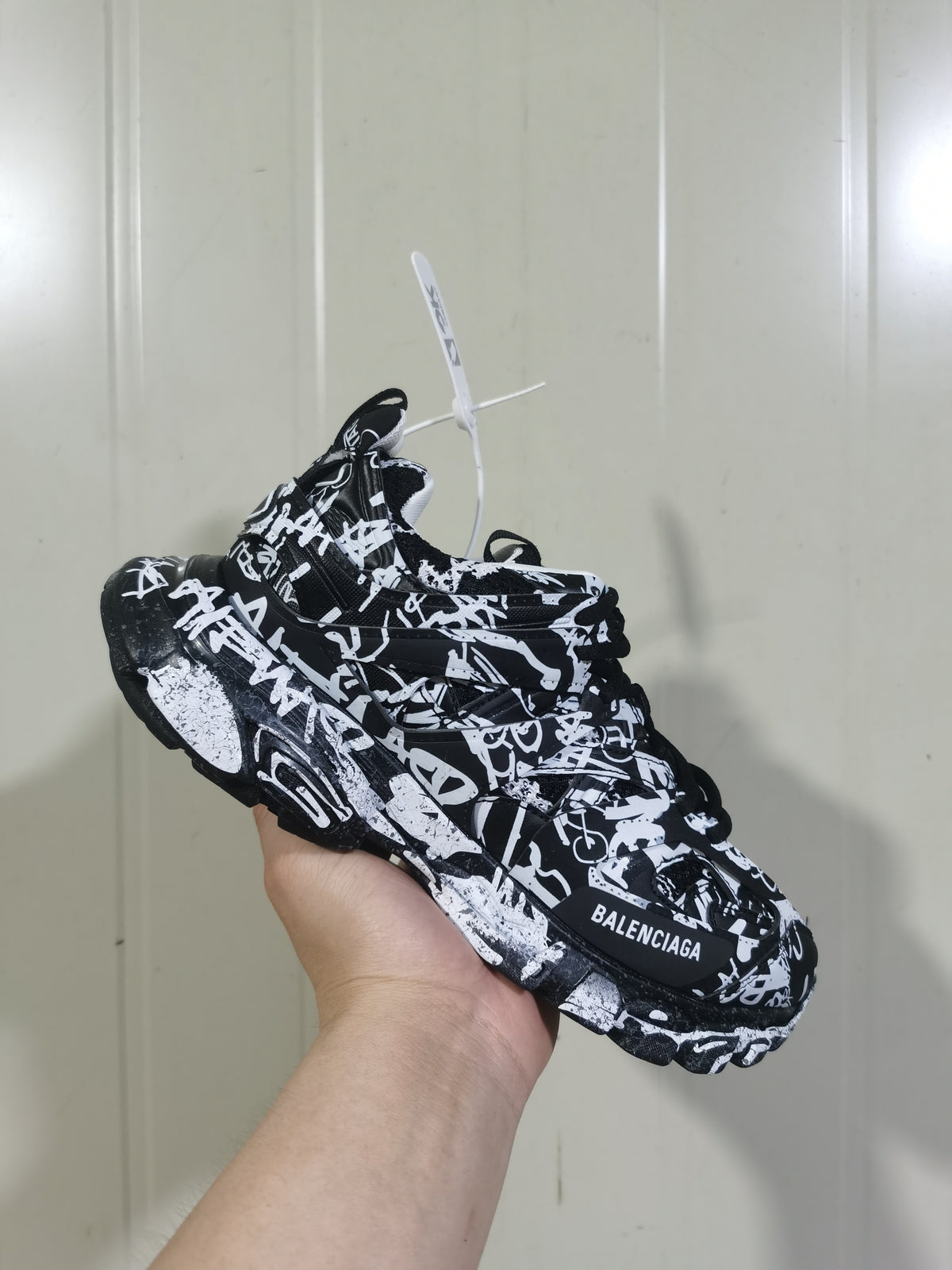 Balenciaga Track 3.0 sneaker shown from an angled side view in a black-and-white graffiti-style pattern.