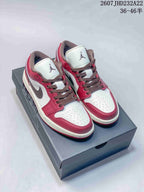 Pair of red, white, and dark brown low-top sneakers displayed on a shoebox.