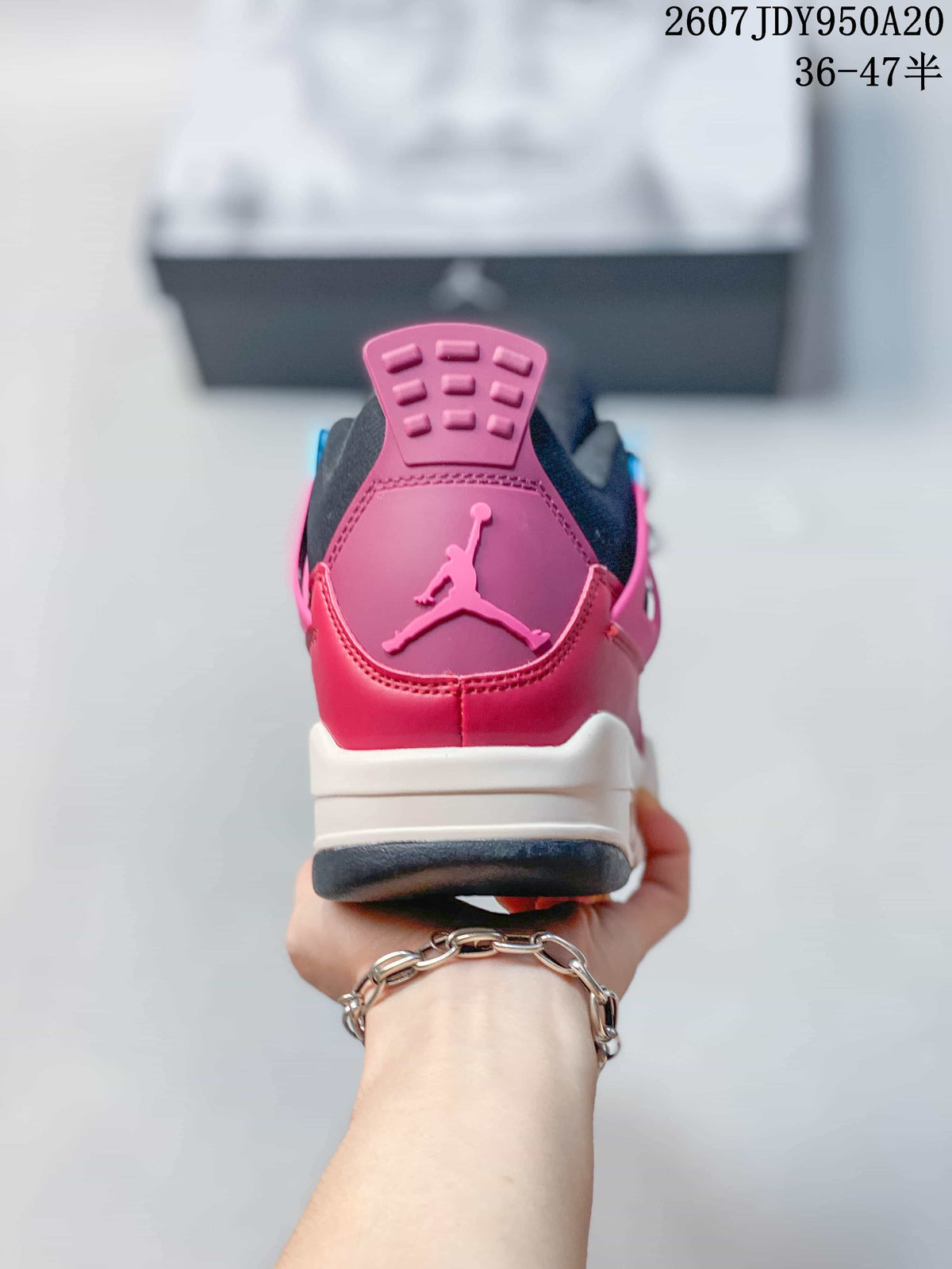 Rear view showing the pink heel panel, raised Jumpman logo, black collar, and white midsole.