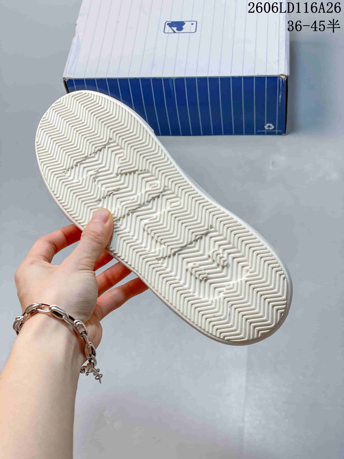 Close view of the white sneaker outsole with a repeating zigzag tread pattern.