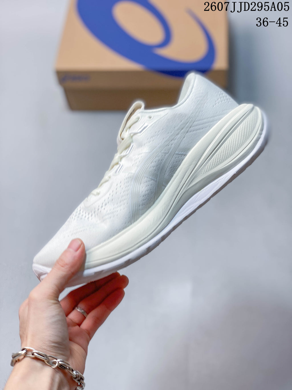Side profile of the white ASICS running shoe showing the mesh upper, layered midsole and outsole.