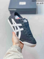 Angled side view of the black and white Onitsuka Tiger sneaker showing the stripes and white toe edge.
