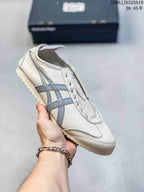 Light-colored low-top sneaker with blue-gray side stripes, shown without laces