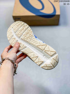 Underside view of an ASICS sneaker showing the patterned outsole tread and ASICS shoe box in the background.