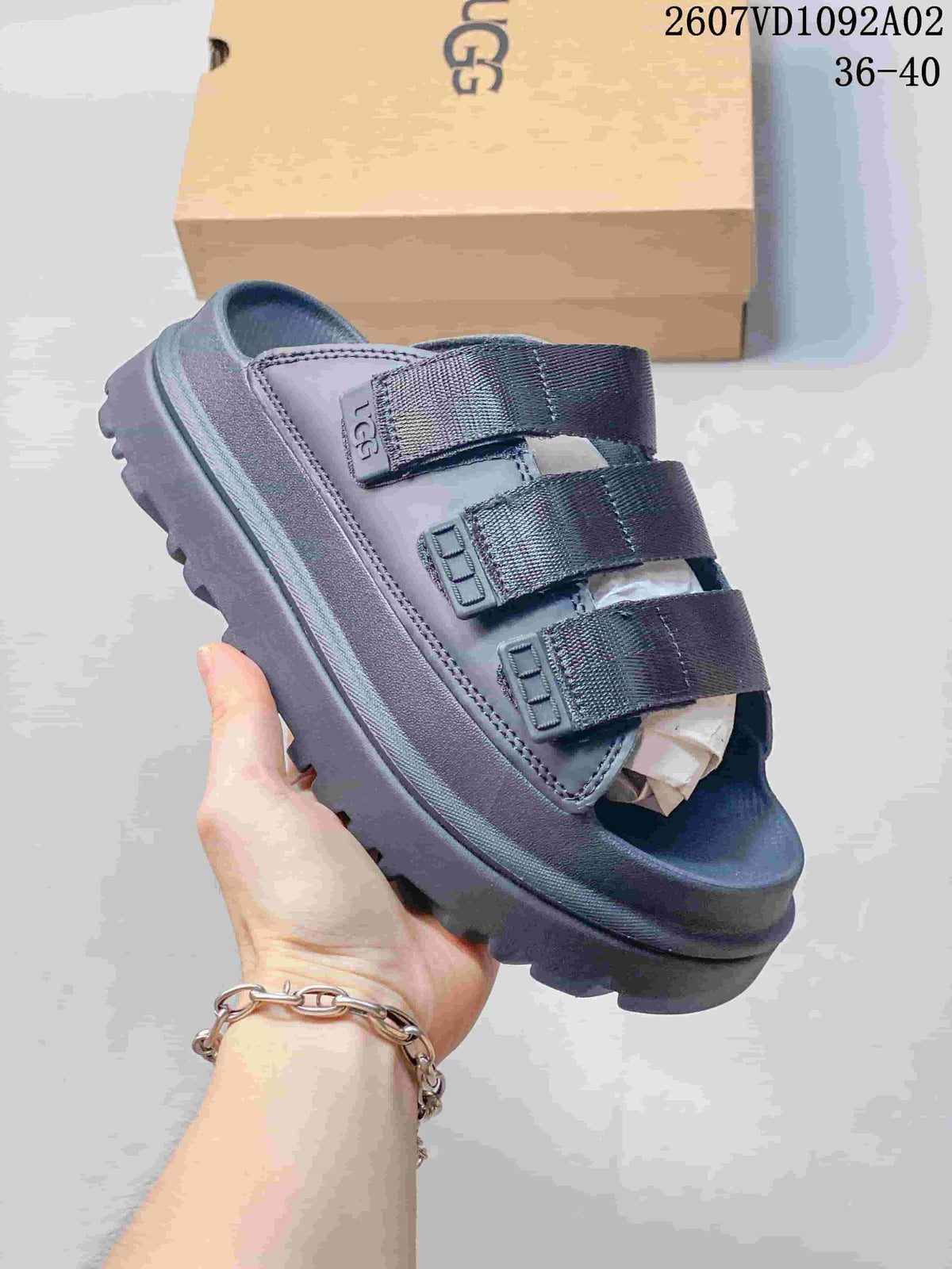 Dark blue-gray slide sandal with three wide straps and a raised, ridged sole.