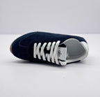 Top view of one deep blue sneaker showing the white laces, tongue branding, and white interior.