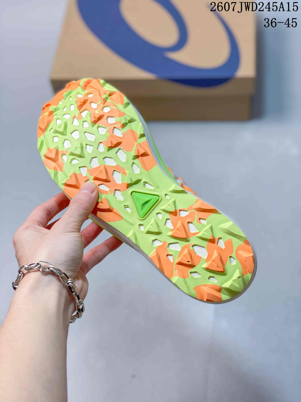 Bottom view of the sneaker showing the lime-and-orange outsole with an open traction pattern; image text shows code 2607TWD245A15 and sizes 36–45.