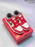 Pair of red, cream, and dark brown Nike SB Dunk Low sneakers on a patterned red box