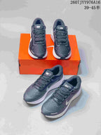Multiple views of the dark gray and white Nike Zoom Structure 23 sneakers arranged around an orange shoe box.