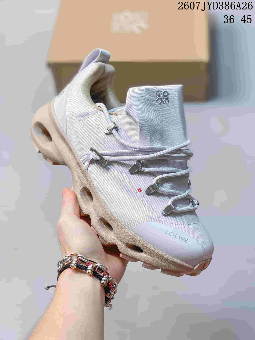 Angled view of a light gray sneaker showing the On and LOEWE markings, cord lacing, padded collar, and sculpted sole.