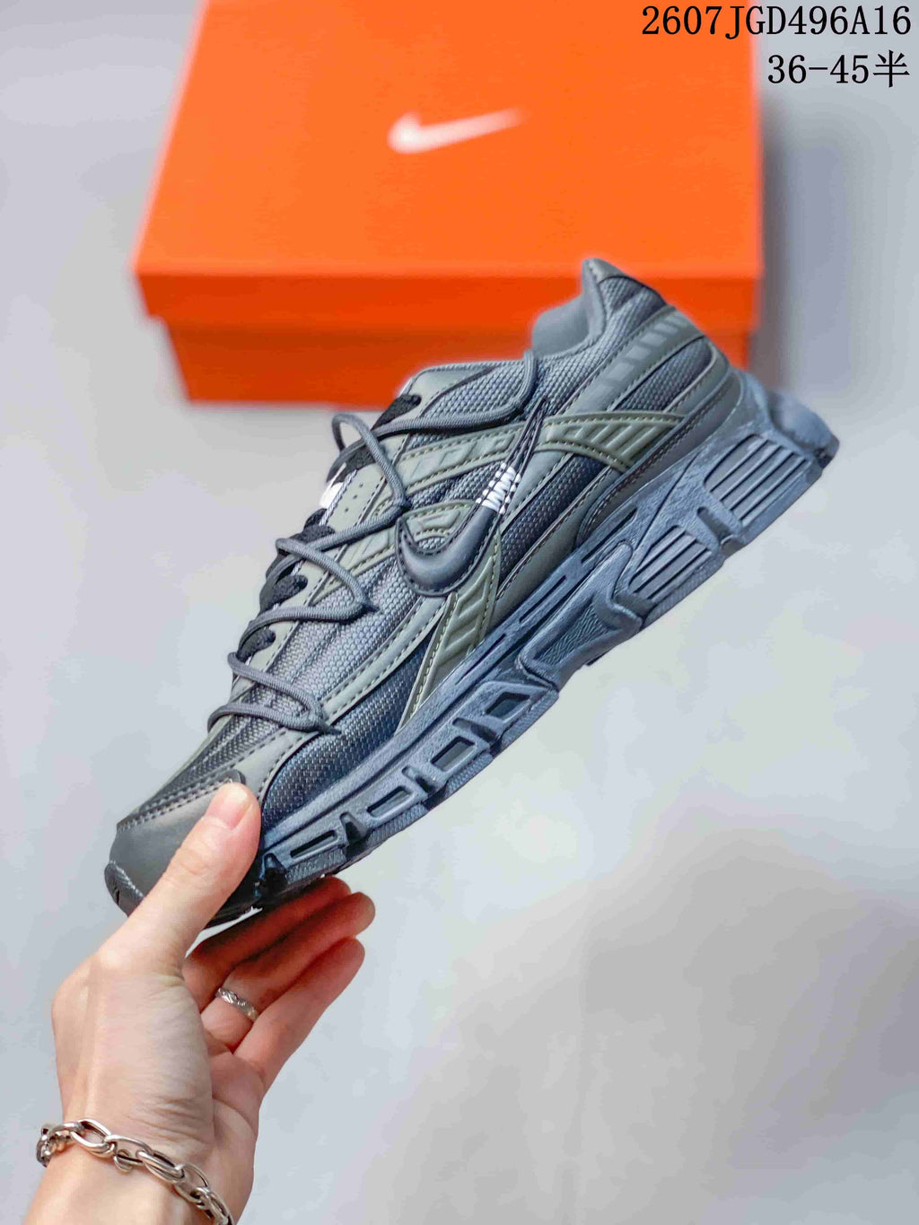 Side view showing the layered gray and olive upper, curved Nike Swoosh and structured sole.