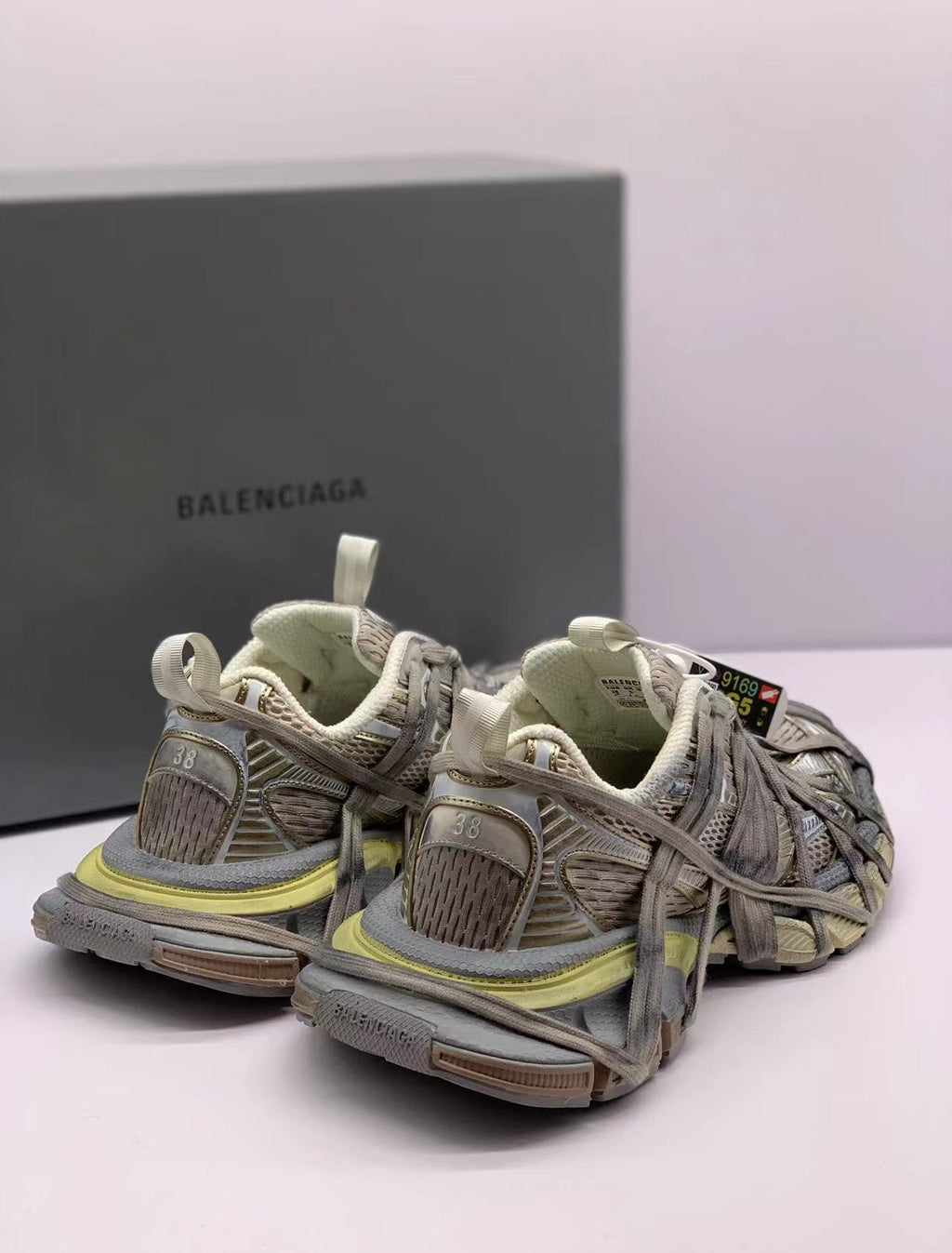 Rear three-quarter product view highlighting the heel panels, pull tabs, layered upper, and outsole.
