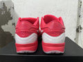 Rear view of vivid pink Nike Kobe basketball shoes with white heel accents.