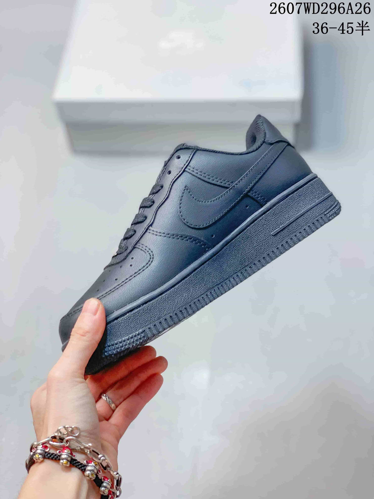 Side view of the black low-top sneaker showing the tonal Swoosh-style side panel, stitching, and raised sole.