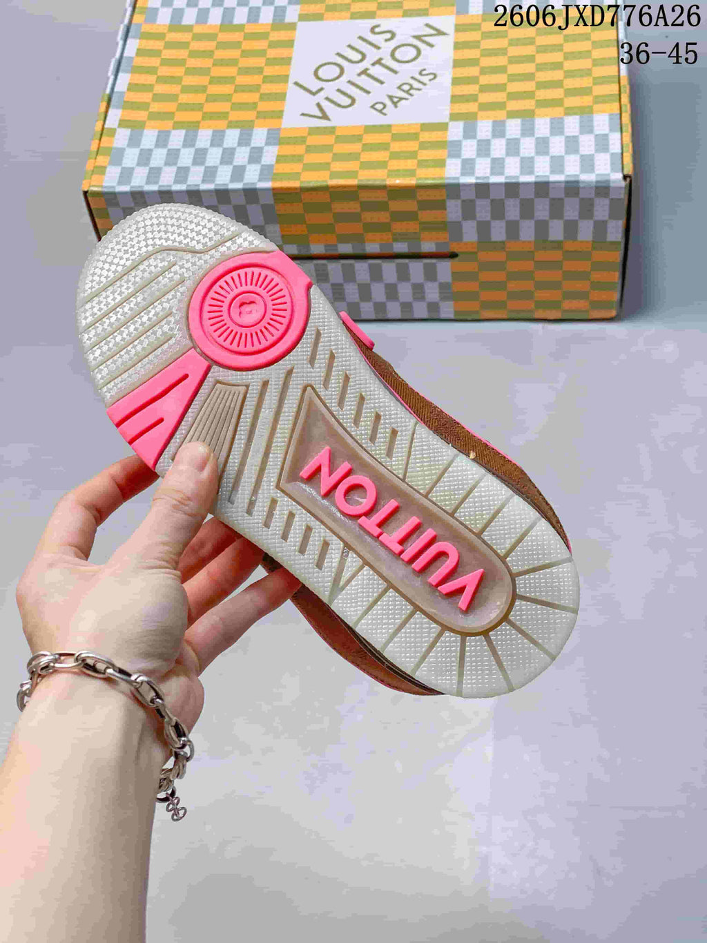 View of the sneaker outsole with a light-colored tread and pink accents