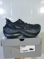 Side view of a black Balenciaga sneaker resting on its box; the box label shows size EU 42 and color BLACK.