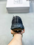 Rear view of a black sneaker showing double white stitching and MMY branding embossed on the heel.