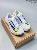 Pair of white Nike Zoom Fly 5 PRM running shoes with blue and neon yellow accents resting on a cardboard shoe box.