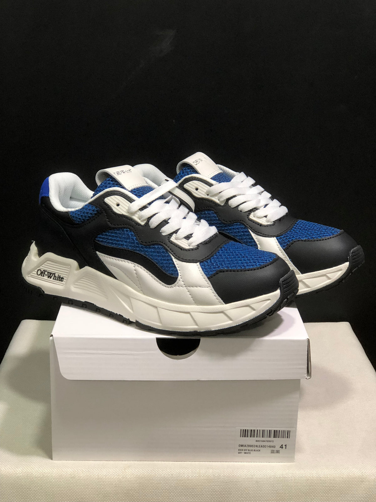 Pair of black, blue, and white Off-White low-top sneakers displayed on a shoebox; the box label shows EU size 41.