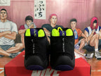 Rear view of black Nike high-top basketball sneakers with neon yellow lining, purple outsole accents, and “THE GLOVE” lettering, displayed on a Nike box.