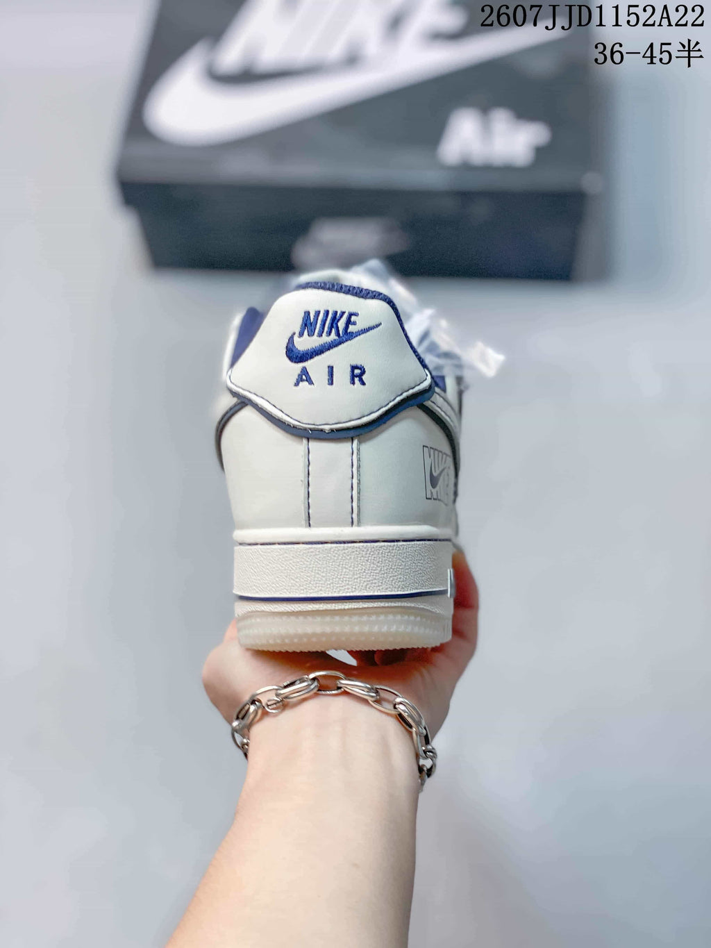 Rear view of the white sneaker showing the Nike Air heel label, layered heel panel and blue collar lining.