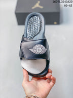 Top view of a dark Jordan slide showing the winged Jordan strap logo and textured footbed; style code 2607LD240A20 and size range 40–45 appear above.
