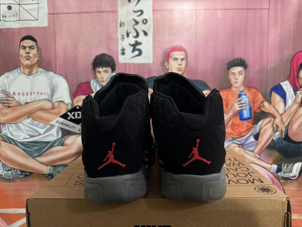 Rear view of black Jordan 23 high-top sneakers with red heel logos and gray soles.