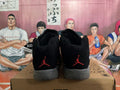 Rear view of black Jordan 23 high-top sneakers with red heel logos and gray soles.