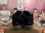Rear view of black Jordan 23 high-top sneakers with red heel logos and gray soles.