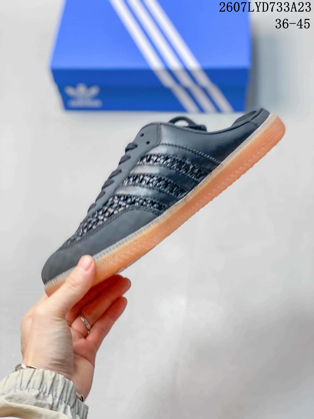 Side profile of the black adidas mule sneaker with woven-texture panels and gum sole
