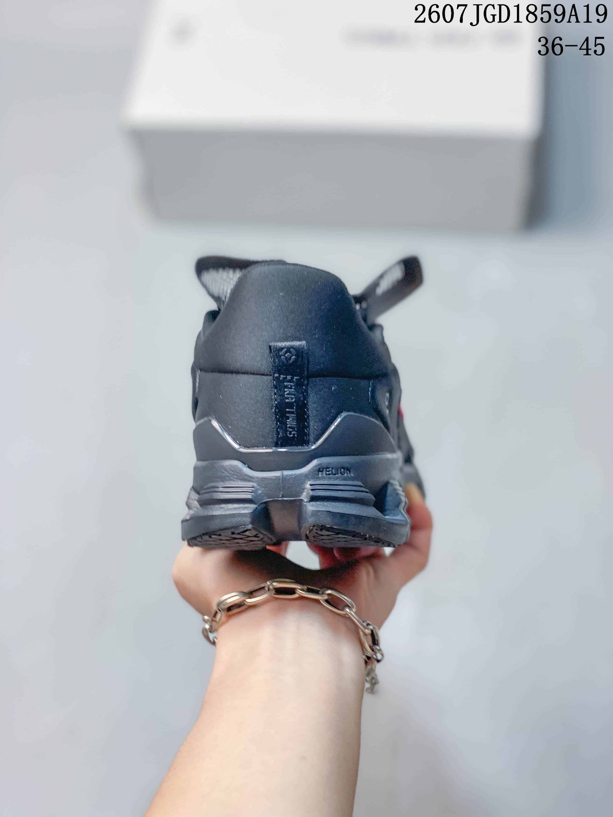 Rear view of the dark sneaker showing the padded heel, pull tab, layered heel structure, and outsole.