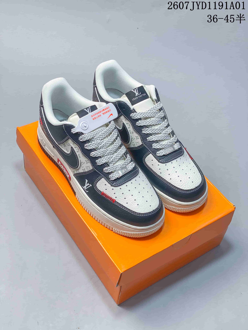 Pair of navy and white low-top sneakers with patterned side panels, shown on an orange box