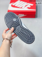 Underside view of the sneaker showing the black circular and grid-textured outsole, with a red Nike shoebox in the background.