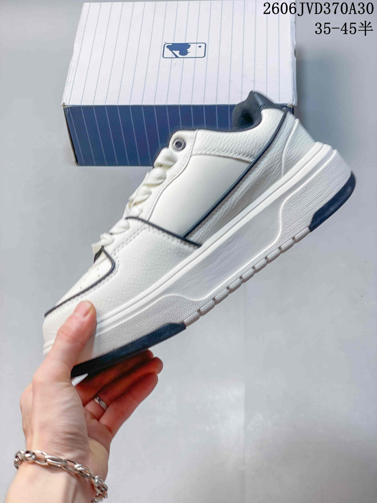 Side profile of a white low-top sneaker with navy piping and a thick sole.
