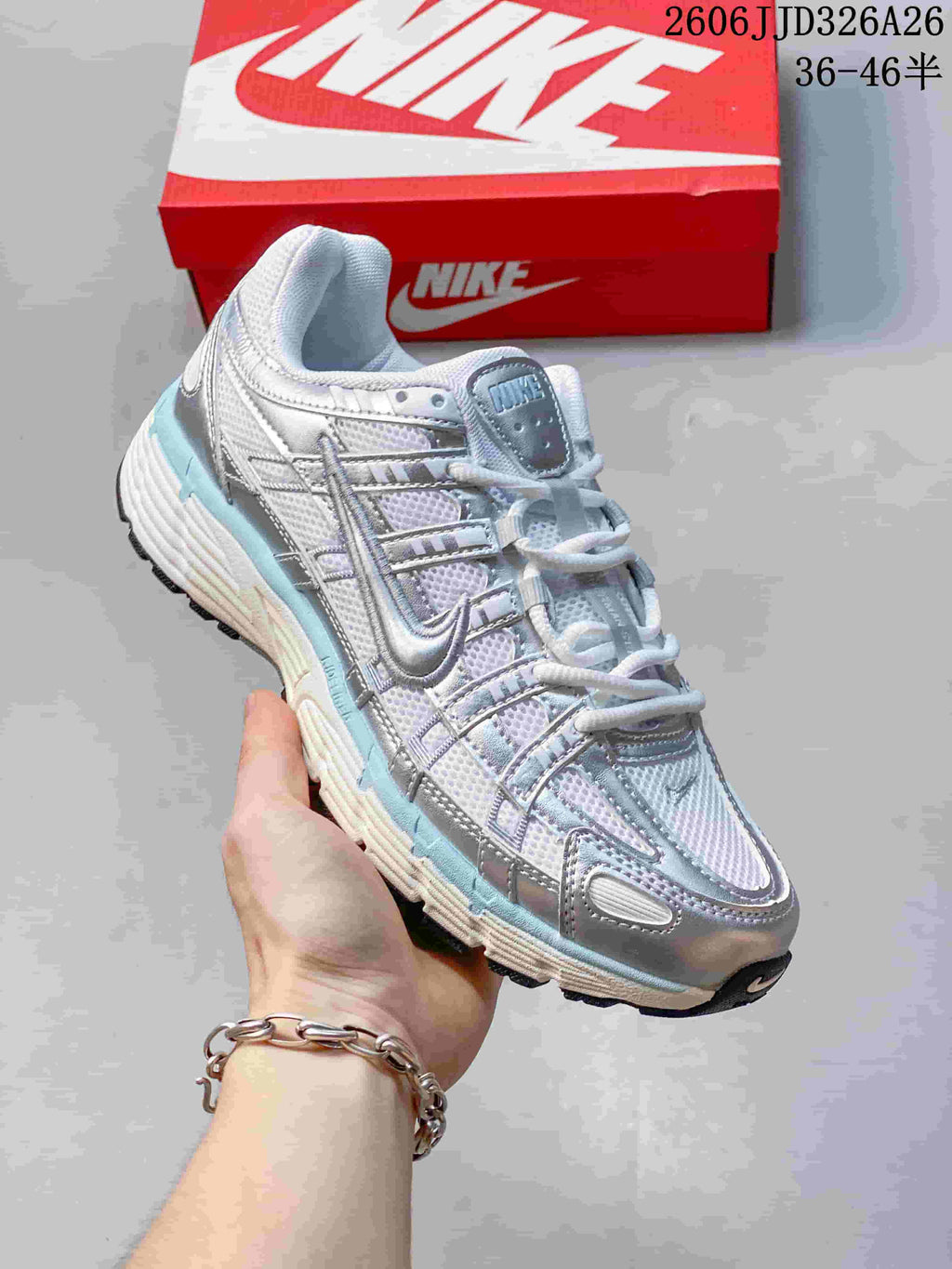 Angled view of a silver and white Nike P-6000 sneaker with pale blue accents