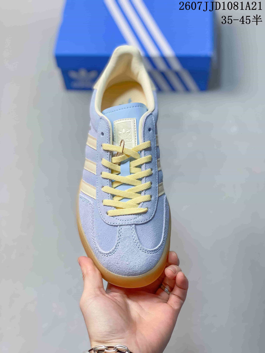 Top view of a light blue sneaker with cream detailing and yellow laces.