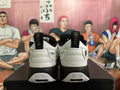 Rear view of white and black Jordan sneakers showing heel branding, pull tabs and patterned outsole details.