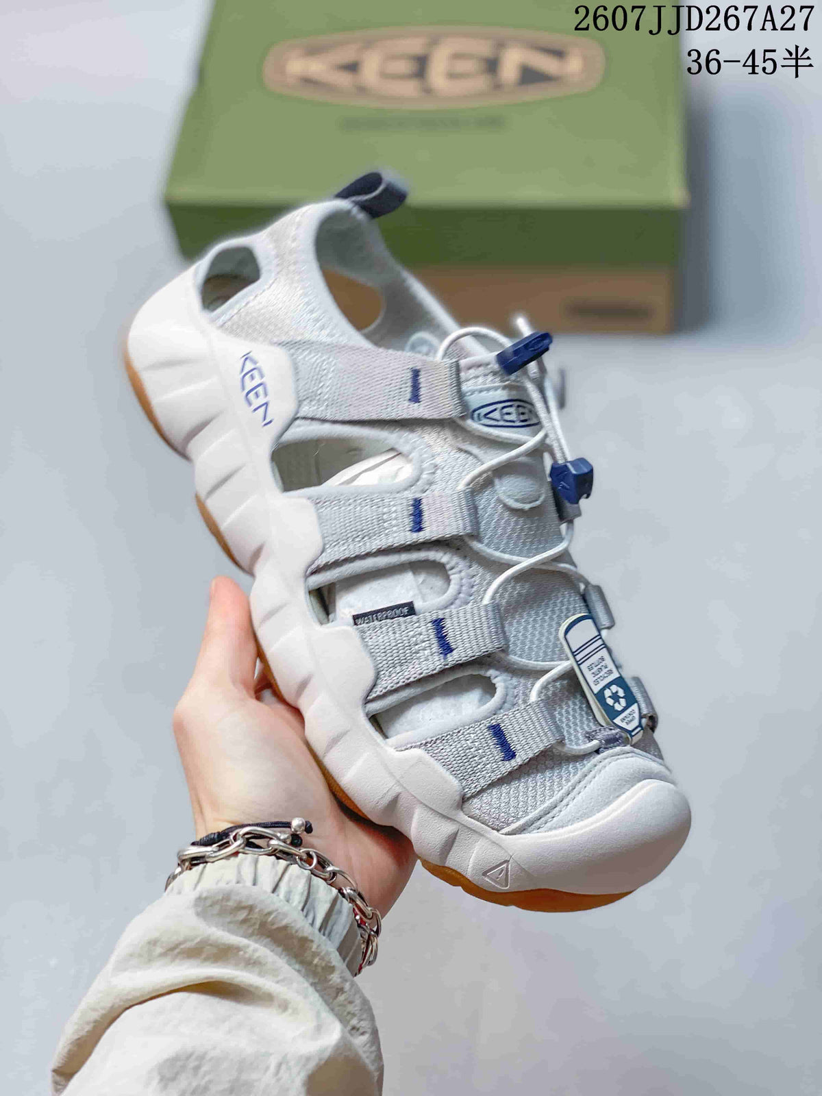 Angled side view of the white and gray KEEN sandal showing the closed toe, open side panels, heel pull tab, and textured gum-colored outsole.