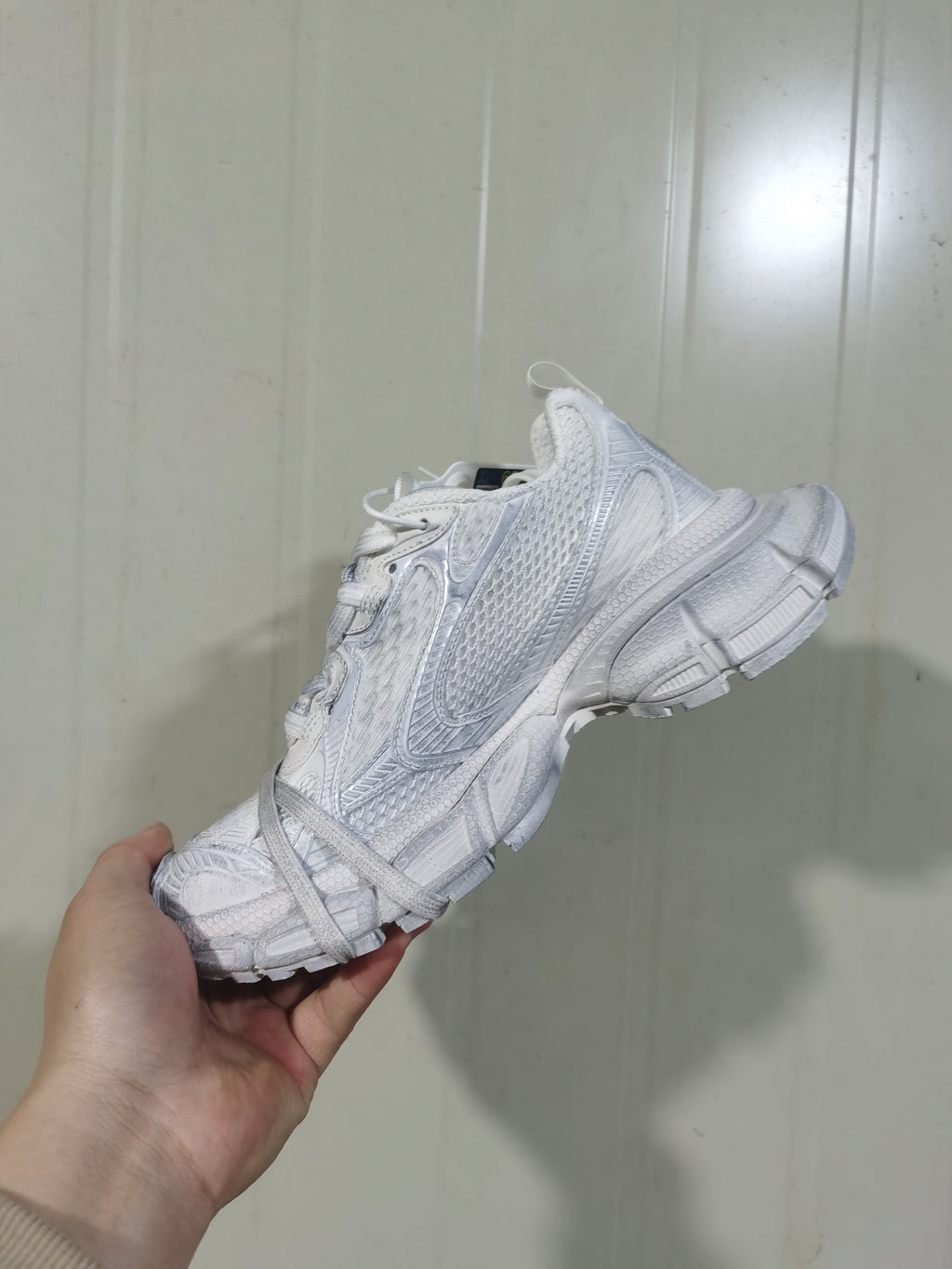 Side and outsole view of the white Nike sneaker, highlighting the Swoosh branding, mesh panel, and chunky sole construction.
