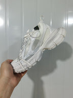 Close-up side view of a snow white Off-White sneaker showing layered panels, textured detailing, pull loops, and a segmented outsole.