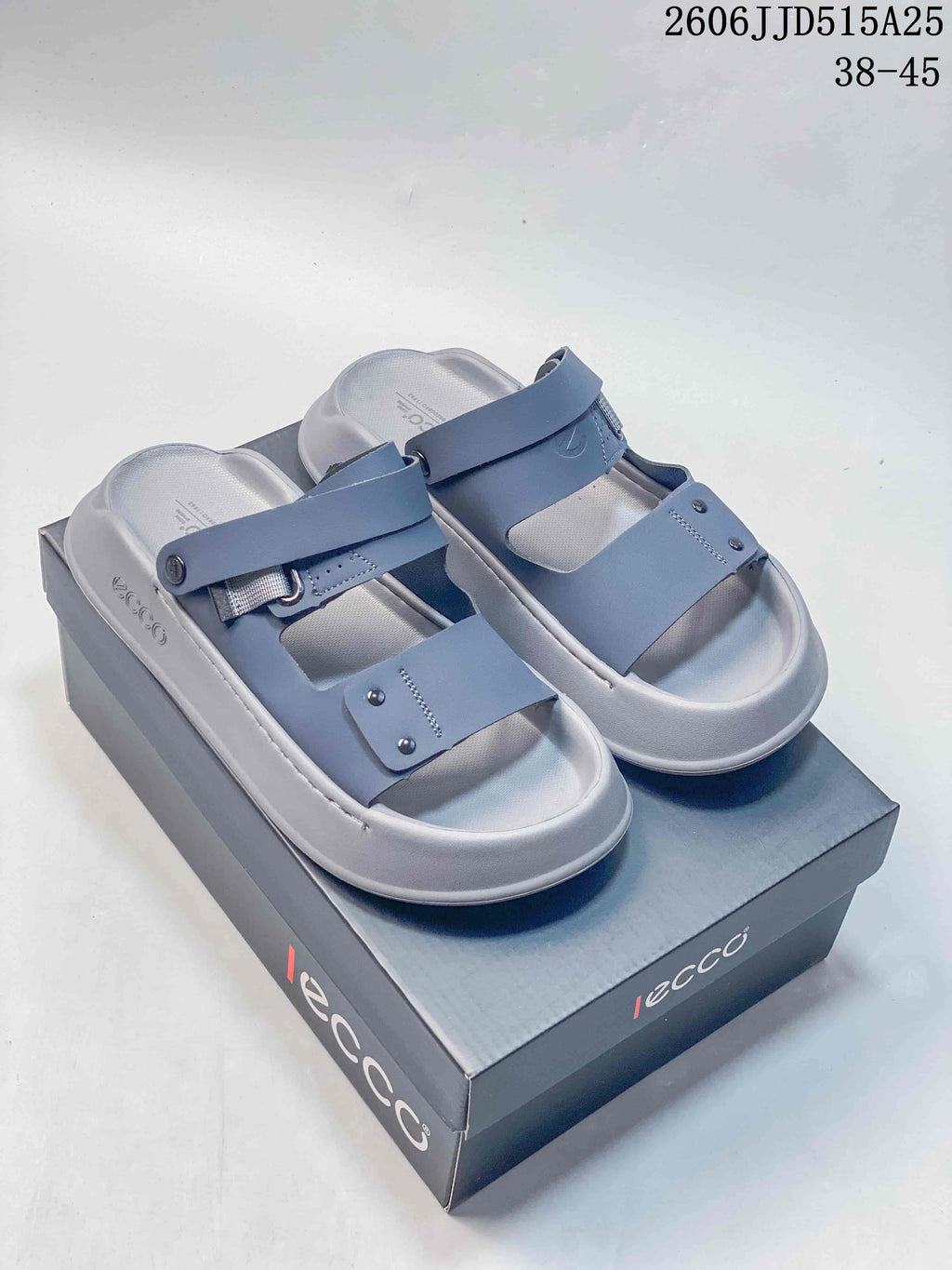 Pair of blue-gray adjustable strap sandals displayed on a box.