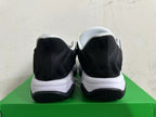 Rear view of black and white Nike sneakers on a green box