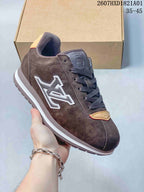 Close view of a dark brown low-top sneaker showing its side emblem, laces and light-colored trim.