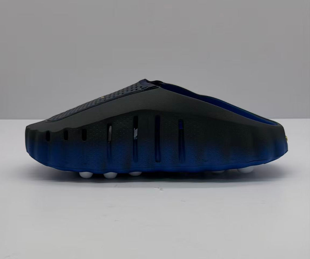 Rear-side view showing ventilation openings and the blue outsole of the slides.
