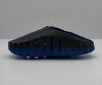Rear-side view showing ventilation openings and the blue outsole of the slides.