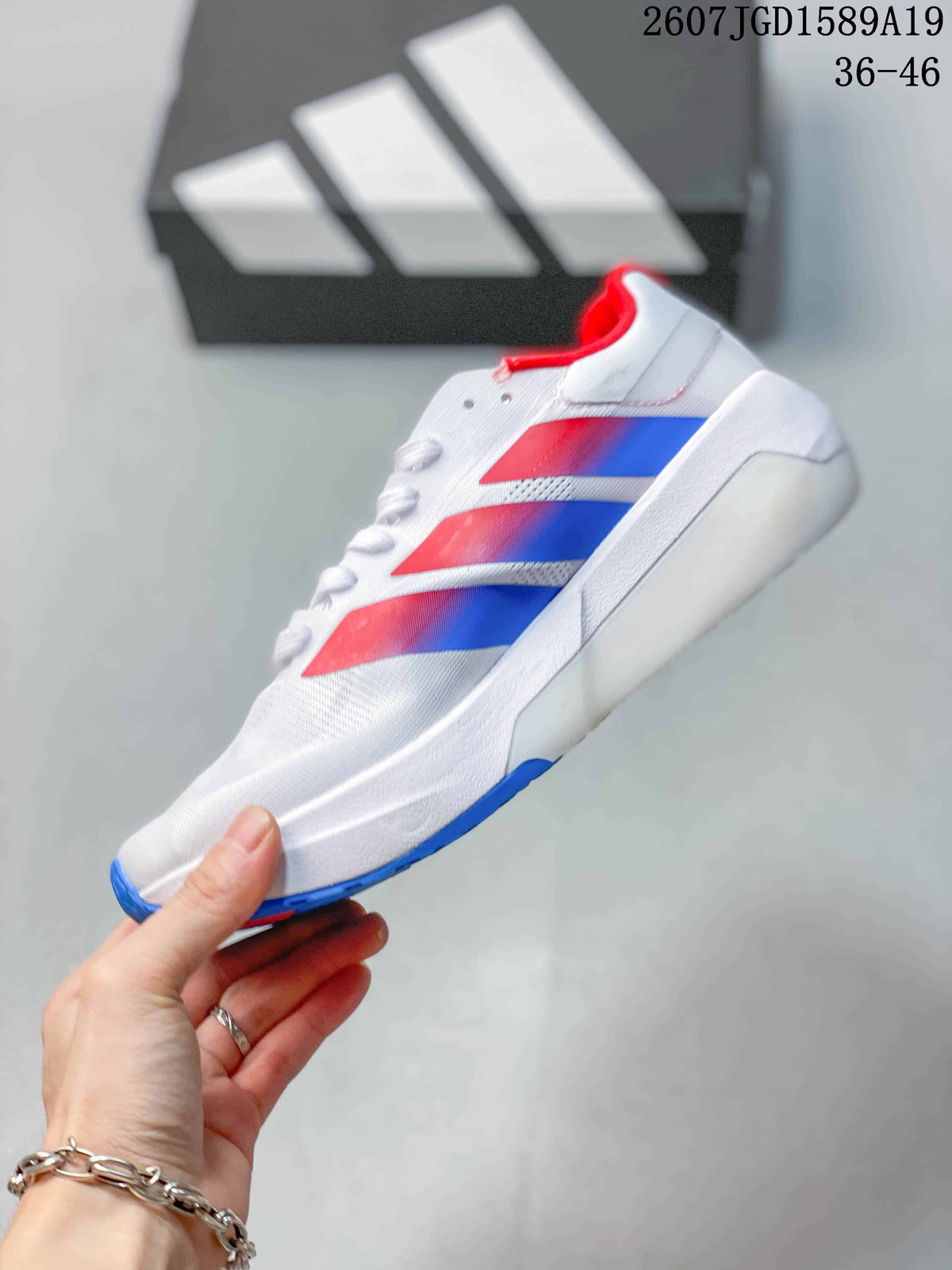 Side profile of the white training sneaker with layered red and blue details and a white midsole.